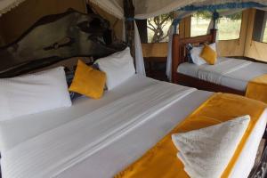 two beds in a room in a tent at Nature Haven Mara Camp in Ololaimutiek