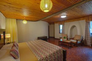 a bedroom with a bed and a chair in a room at Nature Haven Mara Camp in Ololaimutiek
