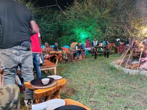a group of people sitting around a camp fire at Nature Haven Mara Camp in Ololaimutiek