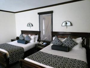 a hotel room with two beds with pillows at Nature Haven Mara Camp in Ololaimutiek