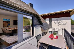 a balcony with a table and a dining area at Wohnen am Weingut - Auf dem Ausguck in Briedel