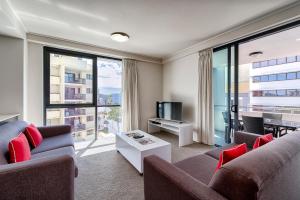 een woonkamer met een bank, een tv en een tafel bij Flynn Brisbane in Brisbane