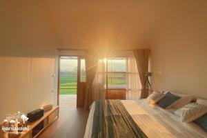 a bedroom with a bed and a large window at หินผาปัว รีทรีต & หินผาโฮมสเตย์ in Ban Choko +32 photos