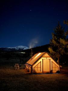 a lit up tent in a field at night at Bosnian Nature Glamping in SJJ
