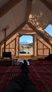 a person laying on a bed in a tent at Bosnian Nature Glamping in SJJ