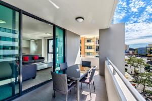 a living room with a balcony and a dining room at Flynn Brisbane in Brisbane