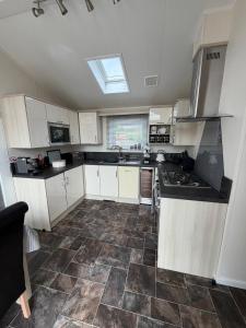 a kitchen with white cabinets and a tile floor at Sunnyside Lodge in Dunning Station