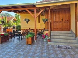 a patio with a table and chairs and a wooden door at Ramonda Serbica - Gorge View & Peacful Nature Retreat in Niš