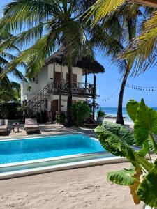 a villa on the beach with a swimming pool at Mango Beach House in Jambiani