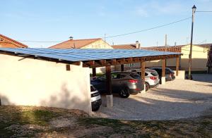 a solar roof on a parking lot with parked cars at Hotel Valdelinares (Soria) in Valdelinares