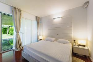 a bedroom with a white bed and a large window at Ladanjsko Imanje Principovac in Ilok