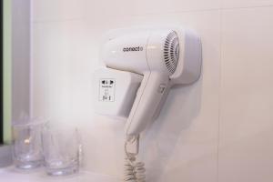 a white hair dryer hanging on a wall at Ladanjsko Imanje Principovac in Ilok