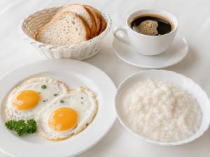a plate of eggs and bread and a cup of coffee at Ak-Kalpak in Cholpon-Ata