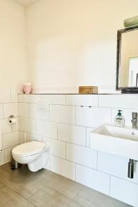 a white bathroom with a toilet and a sink at Der Stader Lieblingsplatz in Stade +9 photos