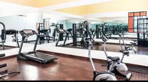 a gym with several treadmills and exercise bikes at Appartement Au vizir avec Accès au Parc de loisirs in Dar Caïd Layadi