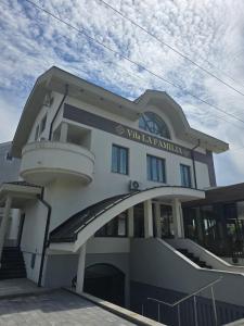 a white building with a sign on the side of it at Vila La Familia in Budžak