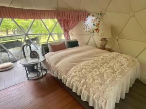 a bedroom with a large bed and a window at 愛犬と泊まるグランピングJuden Camp Fuji in Yamanakako