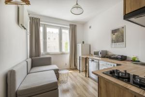 a kitchen and living room with a couch and a table at Labo Apartment - apartamenty Plac Konstytucji in Warsaw