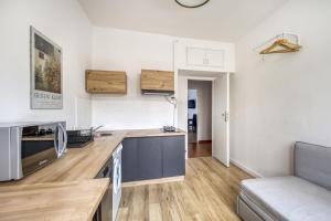 a kitchen and a living room with a couch at Labo Apartment - apartamenty Plac Konstytucji in Warsaw +18 photos