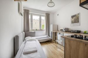 a hospital room with two beds and a kitchen at Labo Apartment - apartamenty Plac Konstytucji in Warsaw