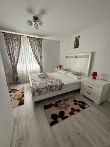 a bedroom with a bed and a dresser and a window at Agropa Rooms & Garden Events in Bistriţa