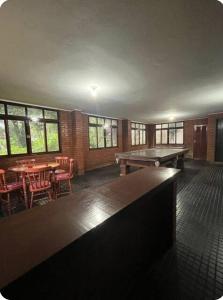 a large room with a ping pong table and chairs at Quarto Imbuí in Teresópolis