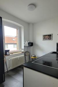 a kitchen with a counter top and a window at Privileg - NewTime in Viersen +18 photos