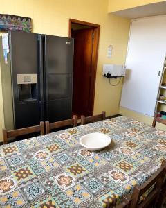 a kitchen with a table with a refrigerator at Quarto Imbuí in Teresópolis +2 photos