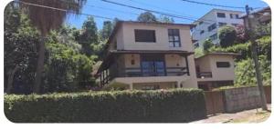a house with a hedge in front of a building at Quarto Imbuí in Teresópolis