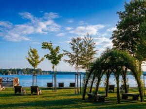 a park with chairs and a view of the water at Domek Ostróda in Ostróda +21 photos