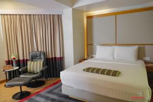 a hotel room with a bed and a chair at Avari Towers Karachi in Karachi +74 photos