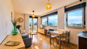 a living room with a table and a dining room at El Arcin - Piscina, terraza y parking en Llanes in Llanes