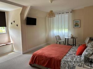 a bedroom with a bed and a table with chairs at Angel du Mont in Pontorson