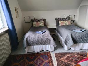 a bedroom with two beds and a rug at Porshøjvej in Skive