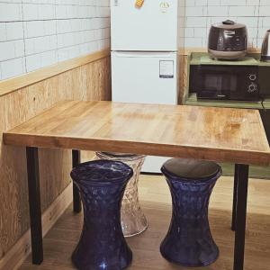 a kitchen with a wooden table and a refrigerator at Pyeonanhan Guesthouse in Hamdŏng-ni
