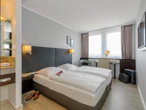 a hotel room with a large bed and a desk at Mercure Hotel Potsdam City in Potsdam +73 photos