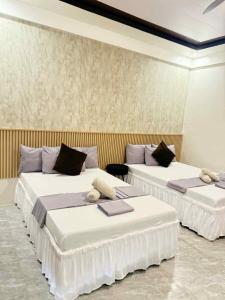 a room with two beds with white sheets at Reynaldos Place Corporation in Vigan +2 photos