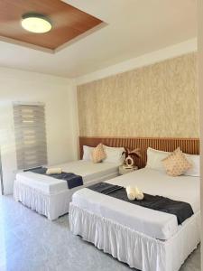 two beds in a hotel room with two beds at Reynaldos Place Corporation in Vigan