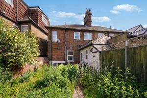 an old brick house with a fence in front of it at Garden Flat In Watford in Watford West Station
