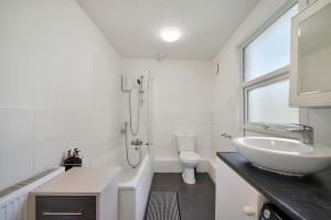 a white bathroom with a sink and a toilet at Garden Flat In Watford in Watford West Station +9 photos