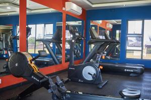 a gym with several tread machines in a room at Sparrow Boutique Hotel in Bulawayo