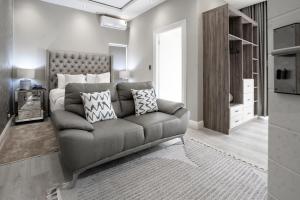 a living room with a couch with pillows on it at Sparrow Boutique Hotel in Bulawayo