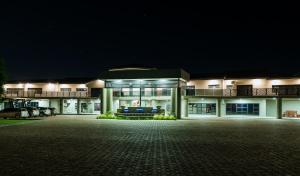 a large building with a parking lot at night at Sparrow Boutique Hotel in Bulawayo