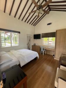 a bedroom with a bed and a ceiling fan at Wadi Al Hasyer Homestay Daisy in Juasseh