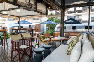 a patio with tables and chairs and blue umbrellas at Grand Daddy Boutique Hotel in Cape Town