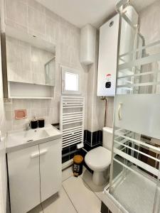 a white bathroom with a toilet and a sink at L'essentiel Gare d'Oullins - 3 chambres - 15 min de Lyon in Oullins