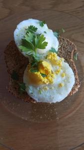a plate with three eggs on a piece of bread at GuestElia Gozo in Nadur
