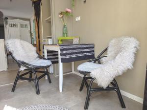 a room with two chairs and a table with fur at Vakantiewoning La Luna OK42 in Oostkapelle +10 photos