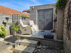 a patio with two chairs and a door at Vakantiewoning La Luna OK42 in Oostkapelle
