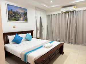 a bedroom with a large bed with towels on it at Serene Resort Pattaya in Nong Prue +9 photos